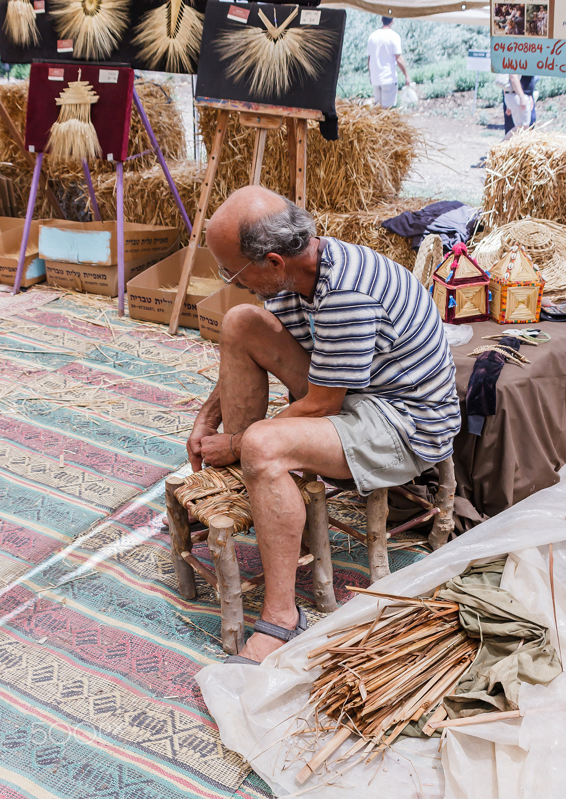 Canon EF 75-300mm F4.0-5.6 IS USM sample photo. Elderly man weaves chair at the fair photography