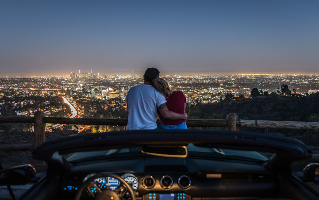 Couple enjoying skyline view from their car by Cristian Negroni on 500px.com
