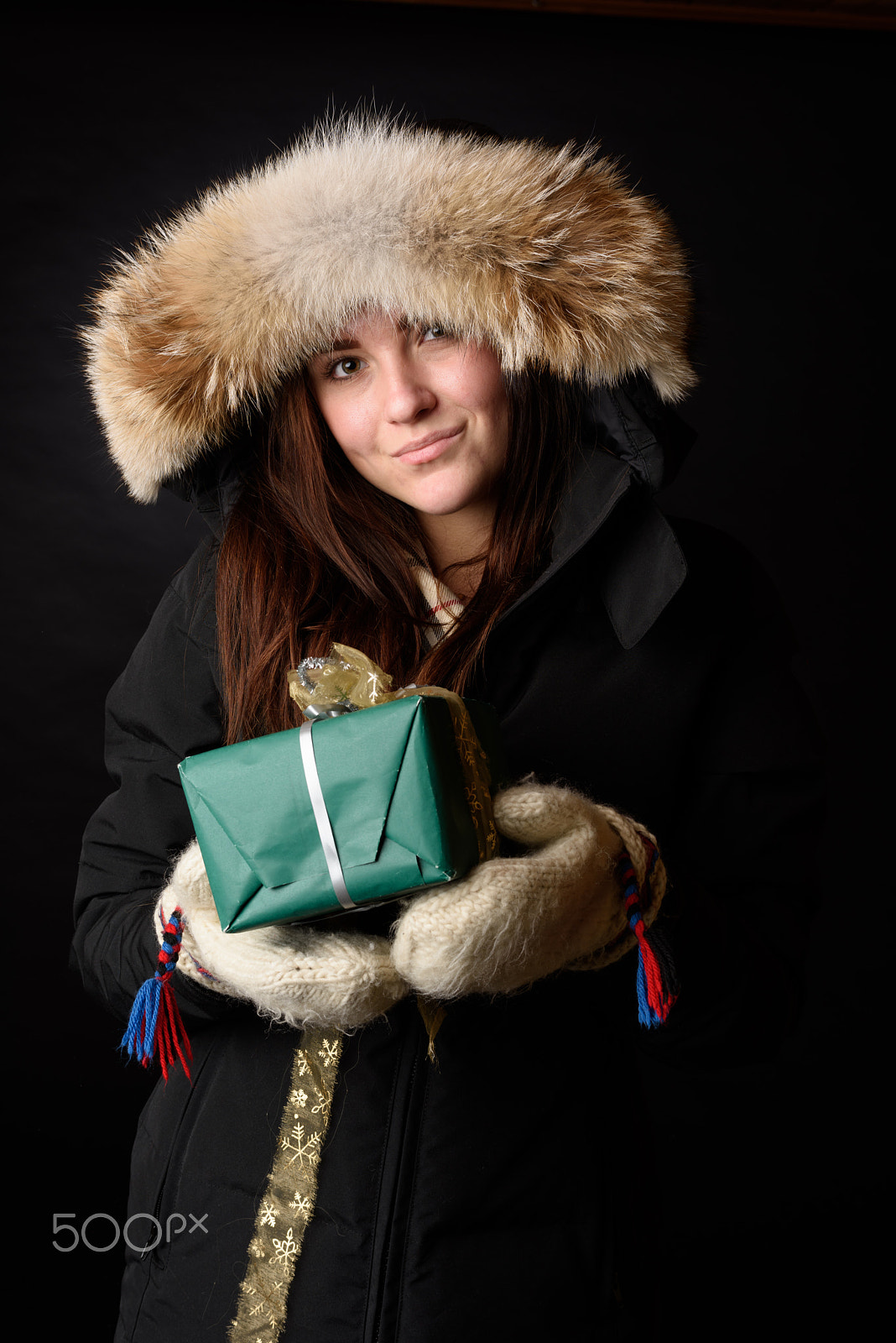 Nikon D810 + Nikon AF-S Nikkor 58mm F1.4G sample photo. Winter dressed young girl with a christmas gift isolated on black background photography