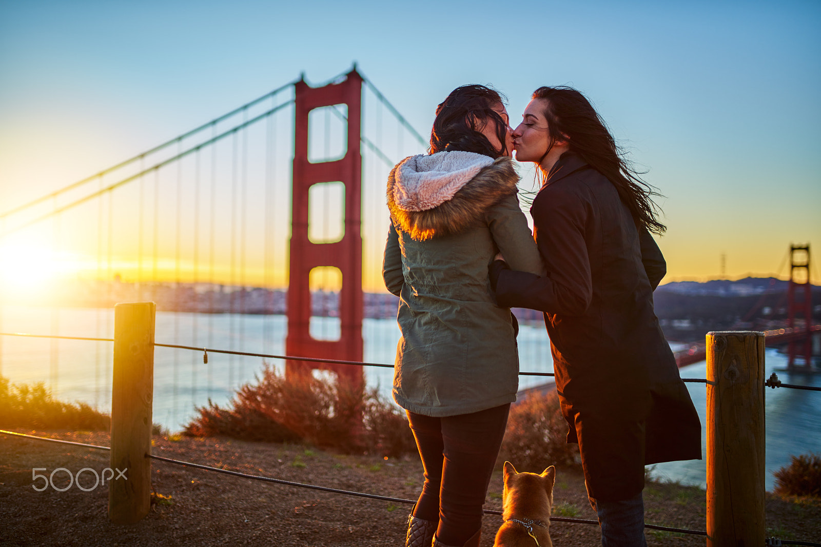 35mm F1.4 G SSM sample photo. Romantic lesbian couple kissing at golden gate bridge with pet dog photography