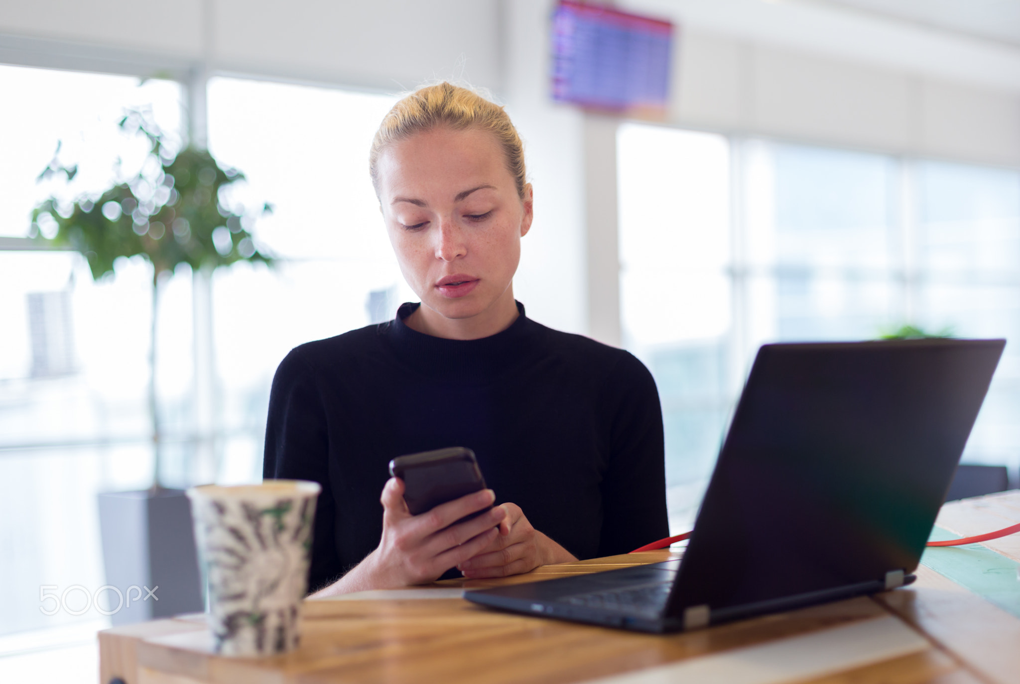 Female freelancer remotely working on the go.