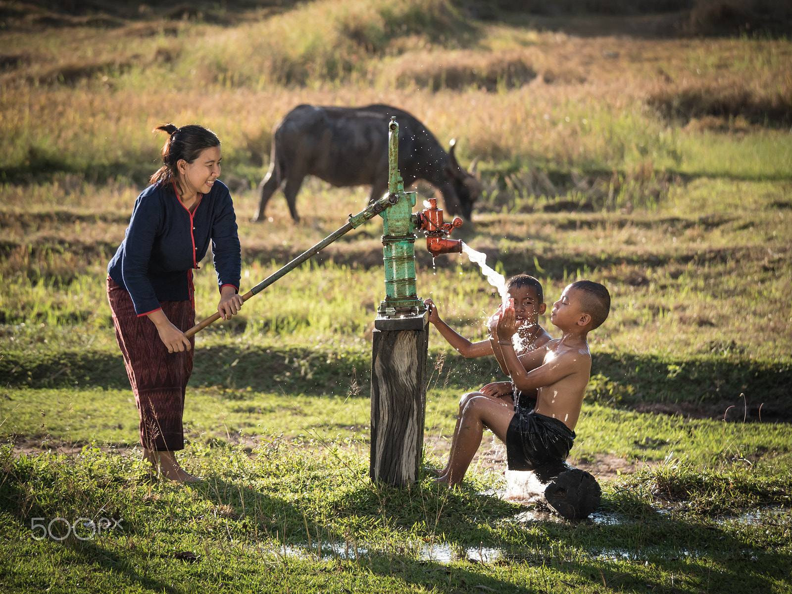Panasonic Lumix DMC-GH4 sample photo. Mother her sons shower outdoor from groundwater pump, countrysid photography