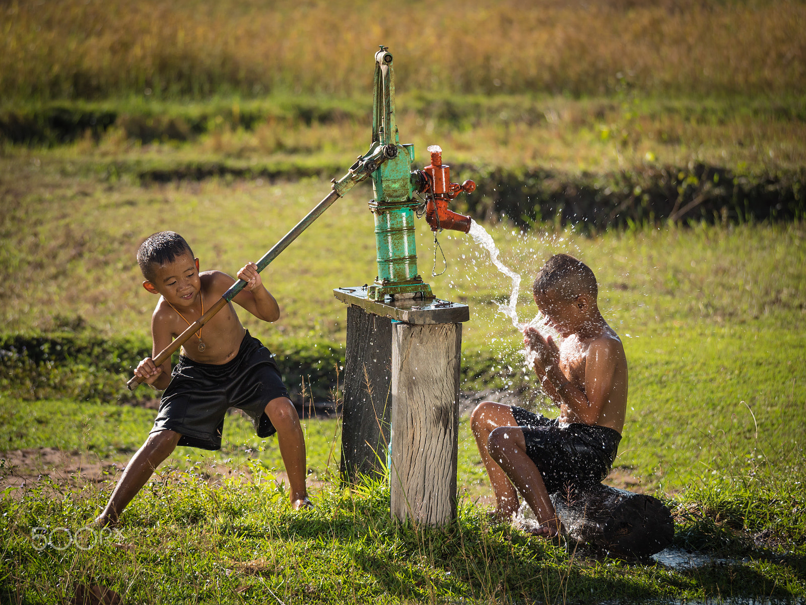 Panasonic Lumix DMC-GH4 + Panasonic Lumix G Vario 100-300mm F4-5.6 OIS sample photo. Two young boy rocking groundwater bathe in the hot days, country photography