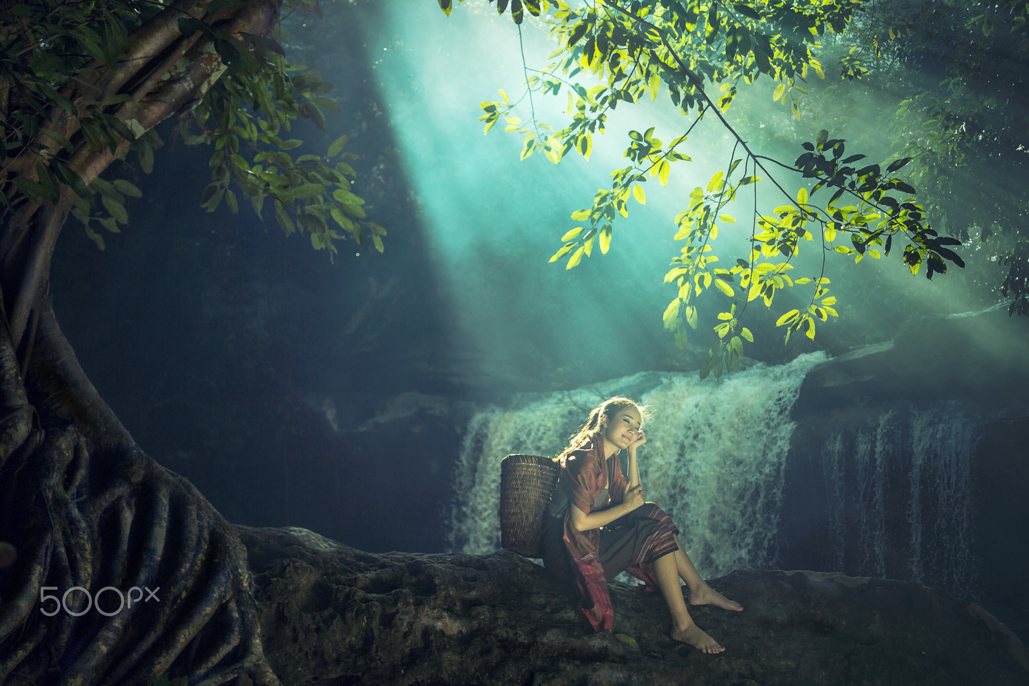 Asian woman sitting alone at the waterfall