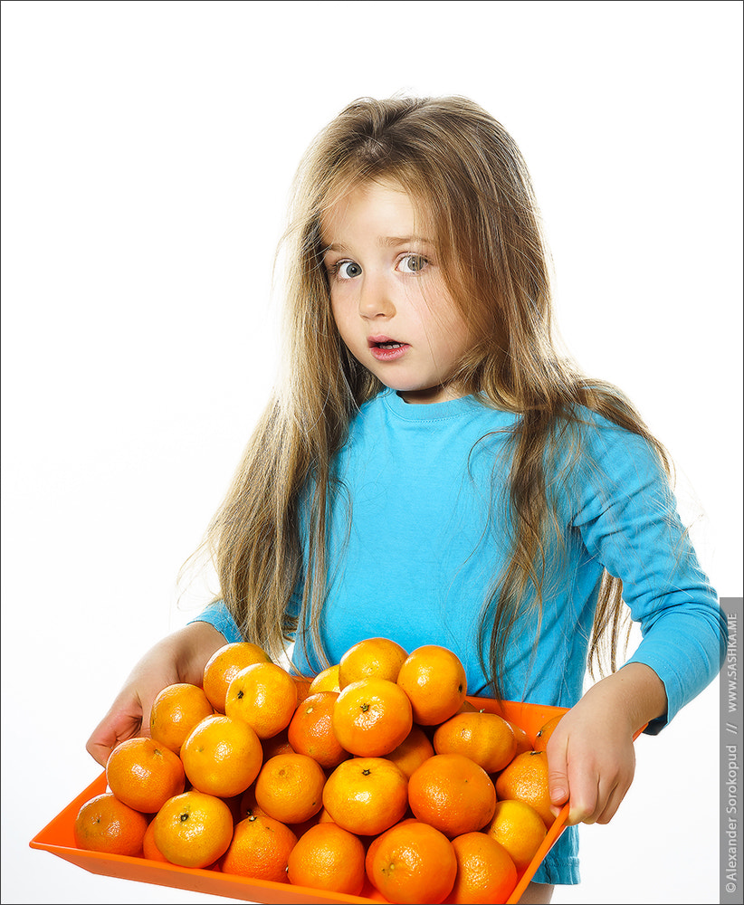 Sony a99 II sample photo. Cute little girl with full tray of mandarins photography