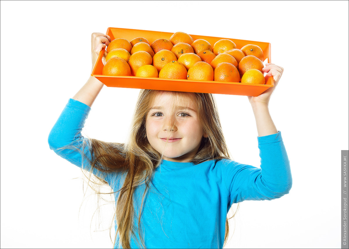 Sony a99 II sample photo. Cute little girl with full tray of mandarins photography