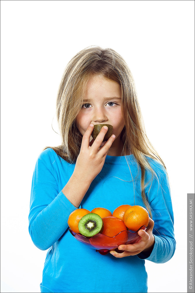 Sony a99 II sample photo. Cute little girl with plate of fruits: kiwi, date plum, mandarin photography