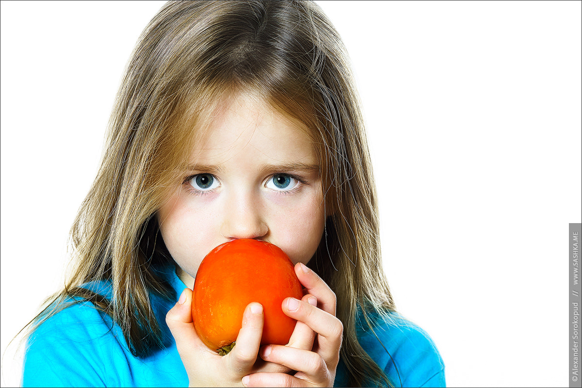 Sony a99 II sample photo. Little girl eating date plum, closeup view photography