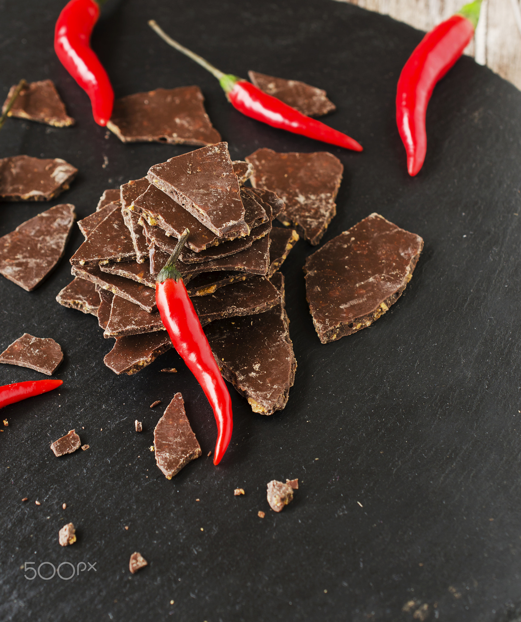 pieces of dark chocolate with chilli on black coal board