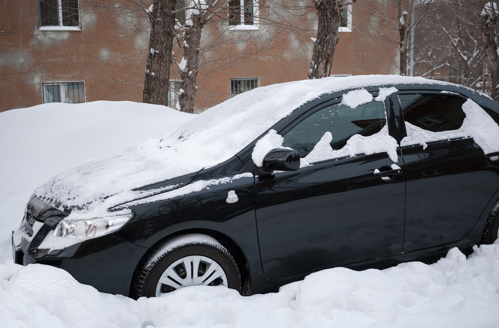 Canon EF-S 24mm F2.8 STM sample photo. Black car covered with snow standing in snowdrift near the house photography