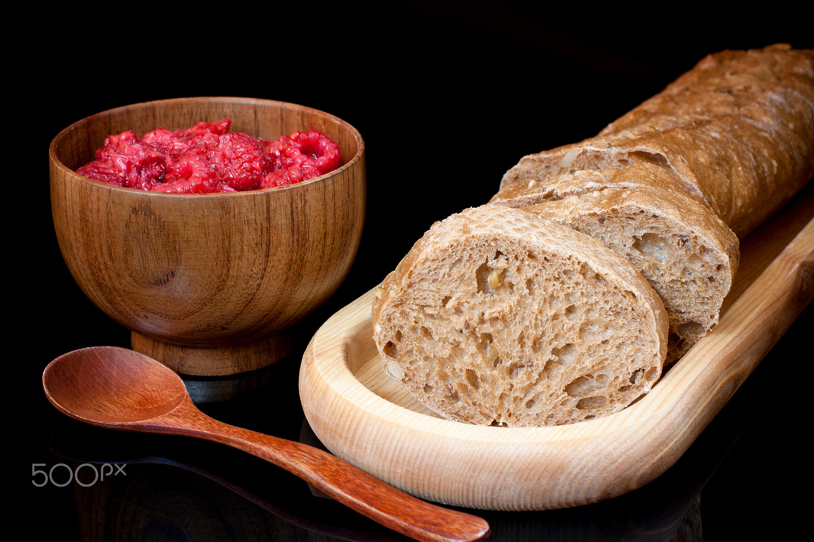 Canon EF 40mm F2.8 STM sample photo. Composition on black background. wooden plate with sliced bread, photography
