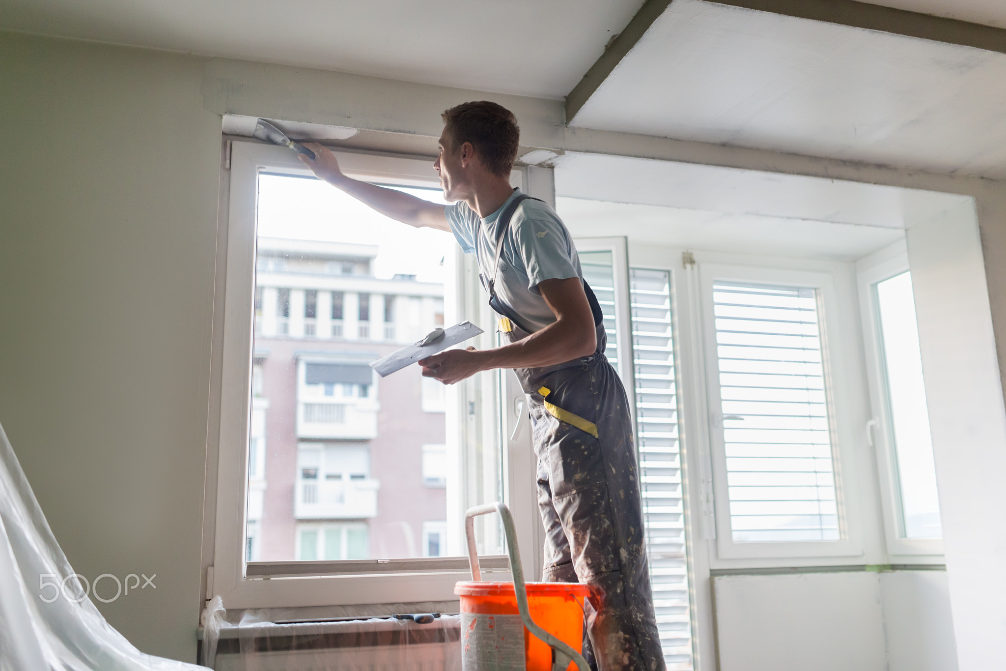 Plasterer renovating indoor walls and ceilings.