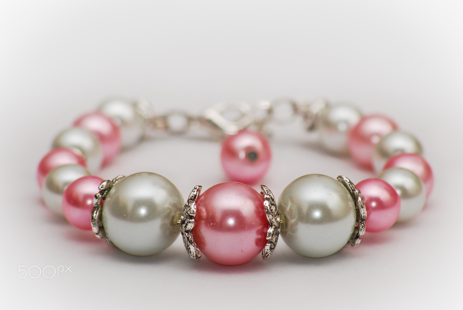 Sigma 70-300mm F4-5.6 APO DG Macro sample photo. A bracelet on a white table photography