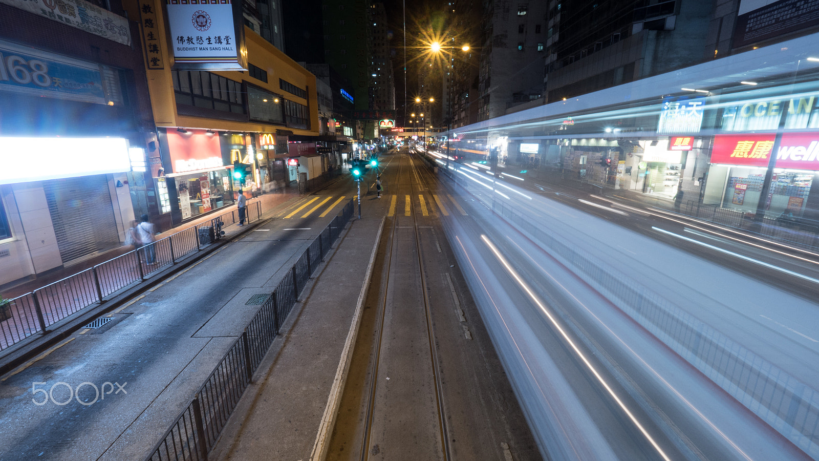 Panasonic Lumix DMC-GH4 + Olympus M.Zuiko Digital ED 7-14mm F2.8 PRO sample photo. Night hong kong street with rail and moving tram photography