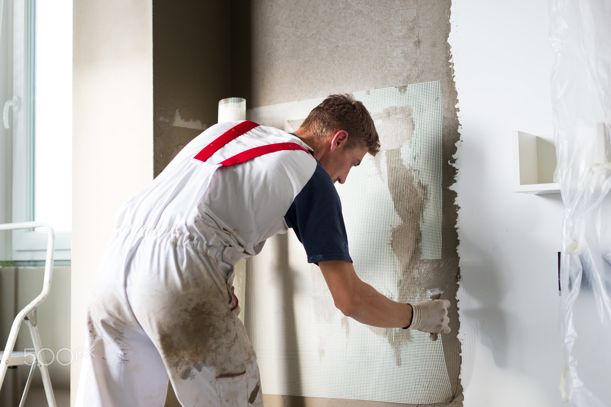 Plasterer renovating indoor walls and ceilings.