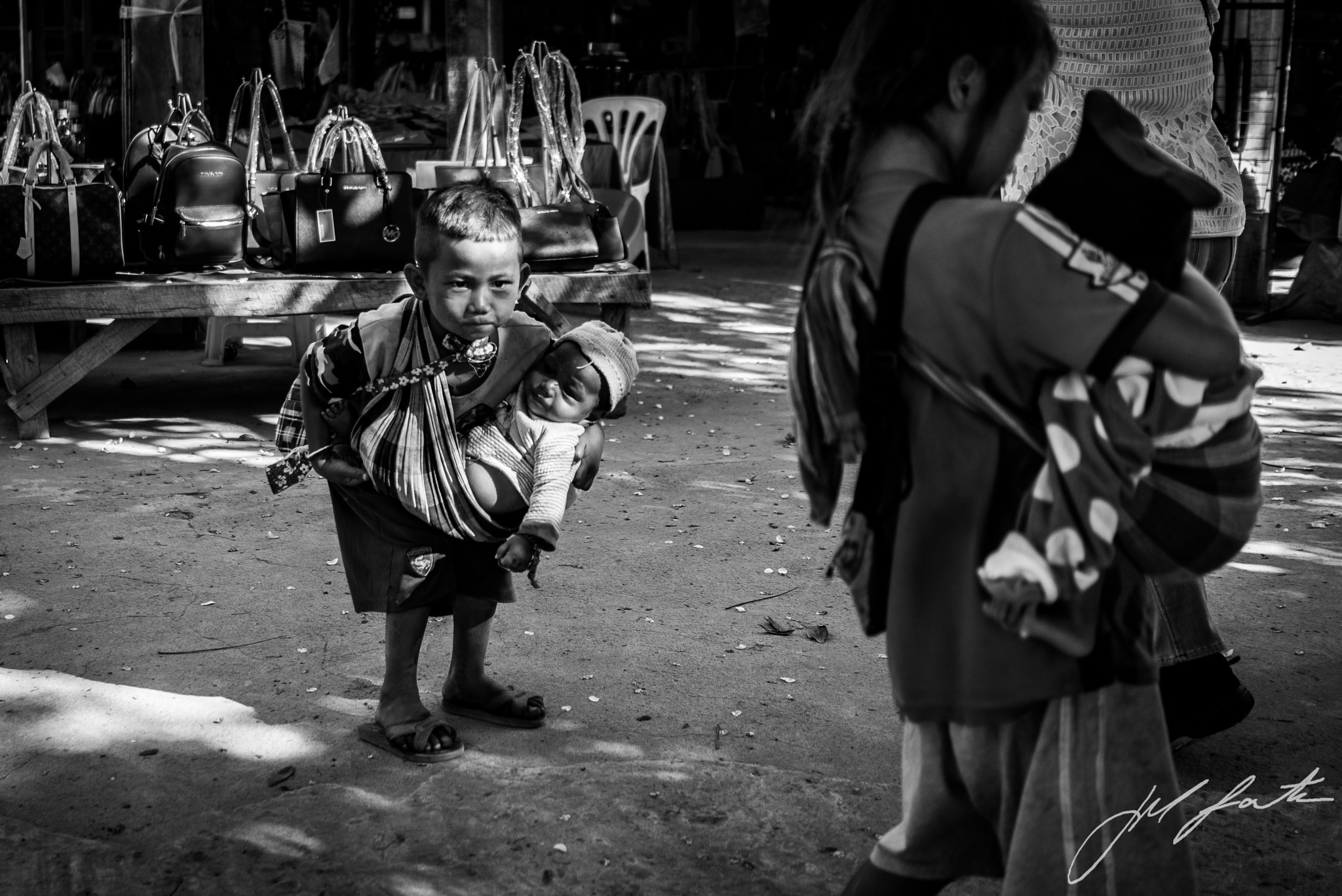 Sony a7R + Sony FE 28mm F2 sample photo. Child carrying child photography