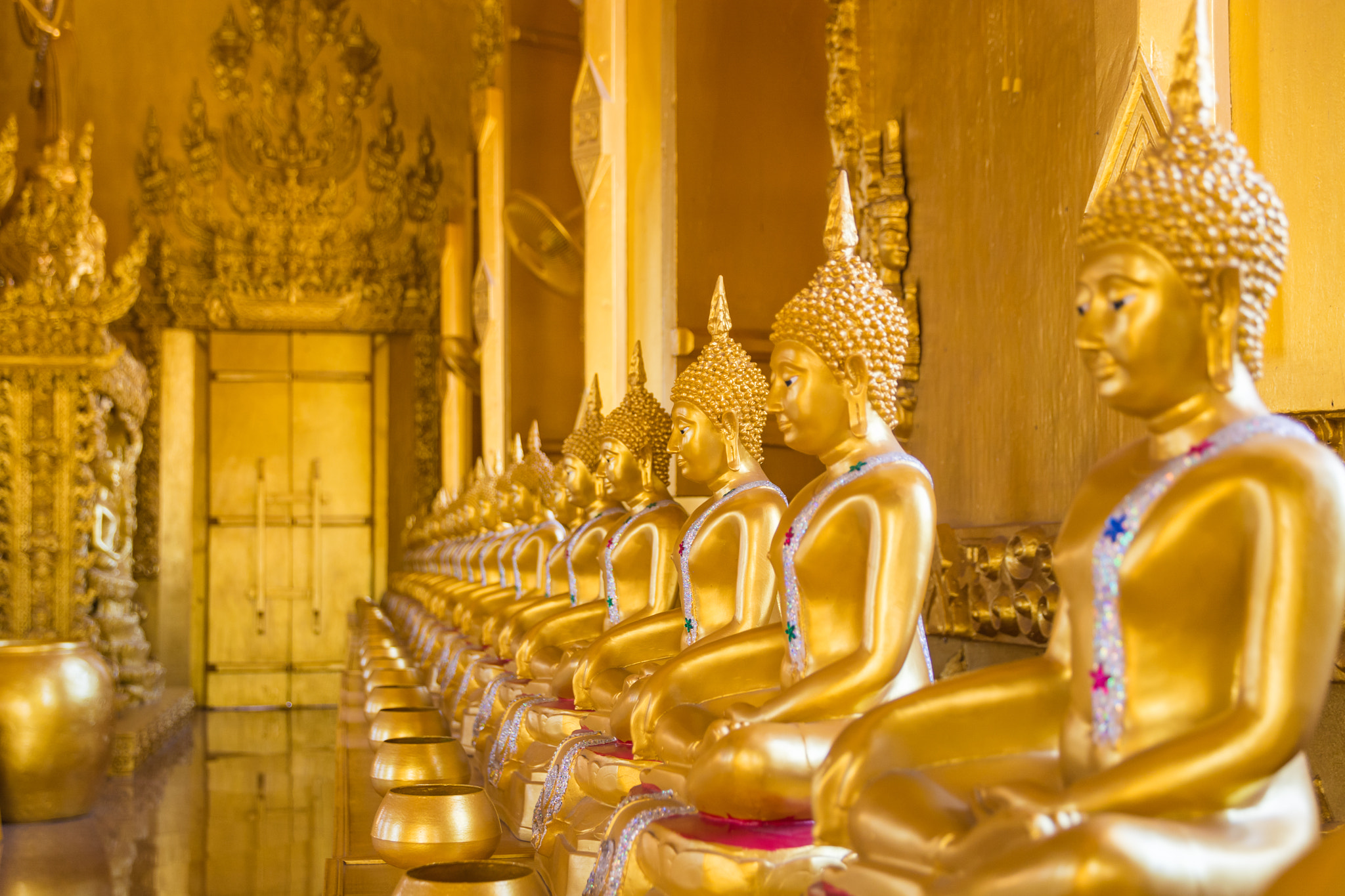 Sigma 17-70mm F2.8-4 DC Macro OS HSM | C sample photo. A row of golden buddha statue. photography