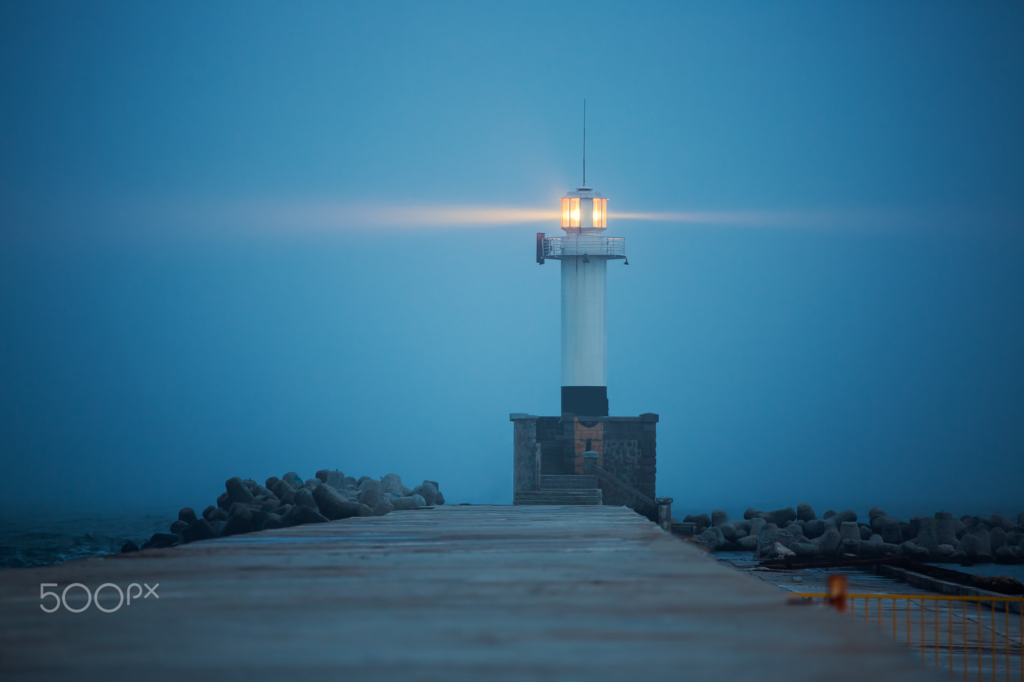 Lighthouse in dense fog and mist, night scene