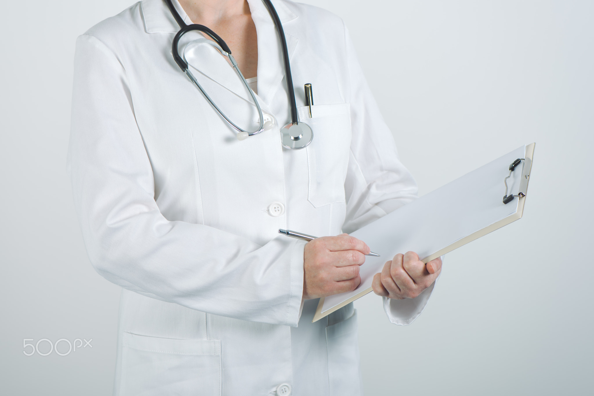 Female doctor writing on clipboard notepad blank paper