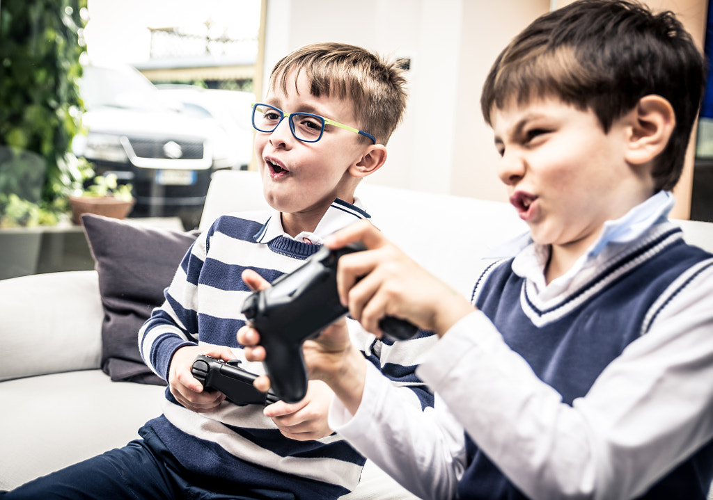 Happy children playing videogames in the living room by Cristian Negroni on 500px.com