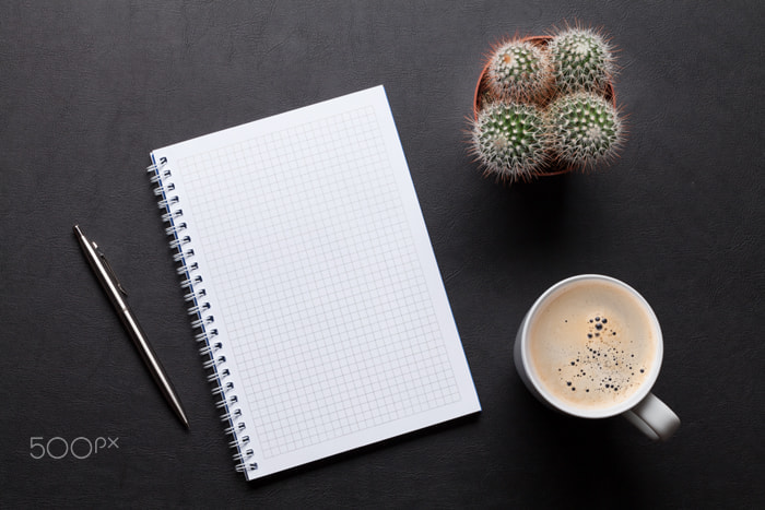 Office leather desk table with notepad, cactus and coffee