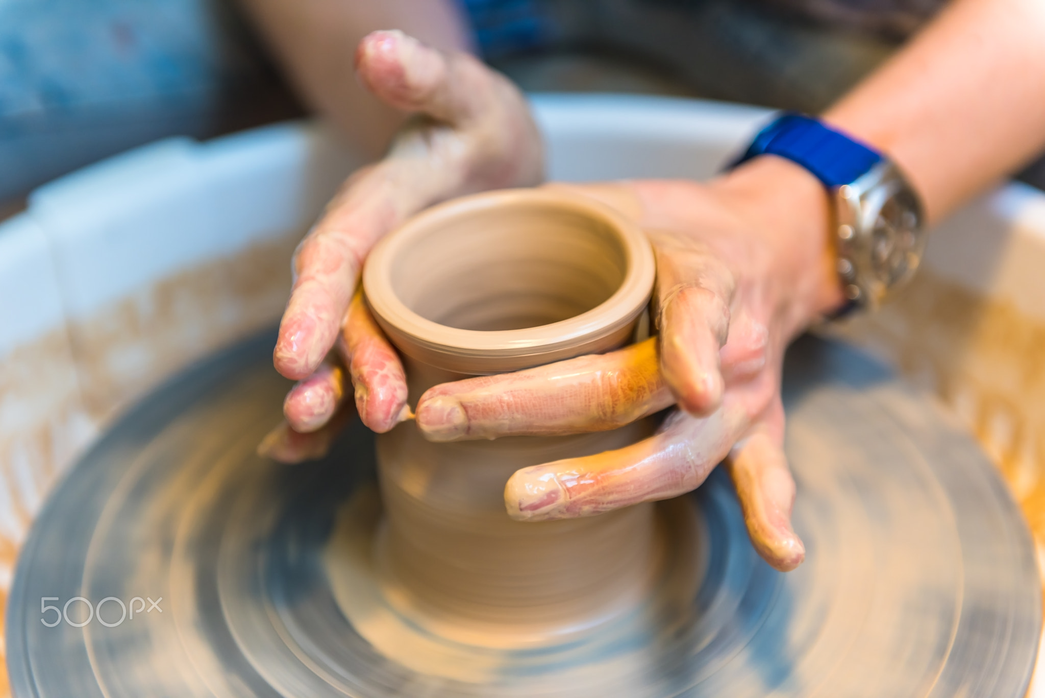 womens hands of a potter creating an earthen jar