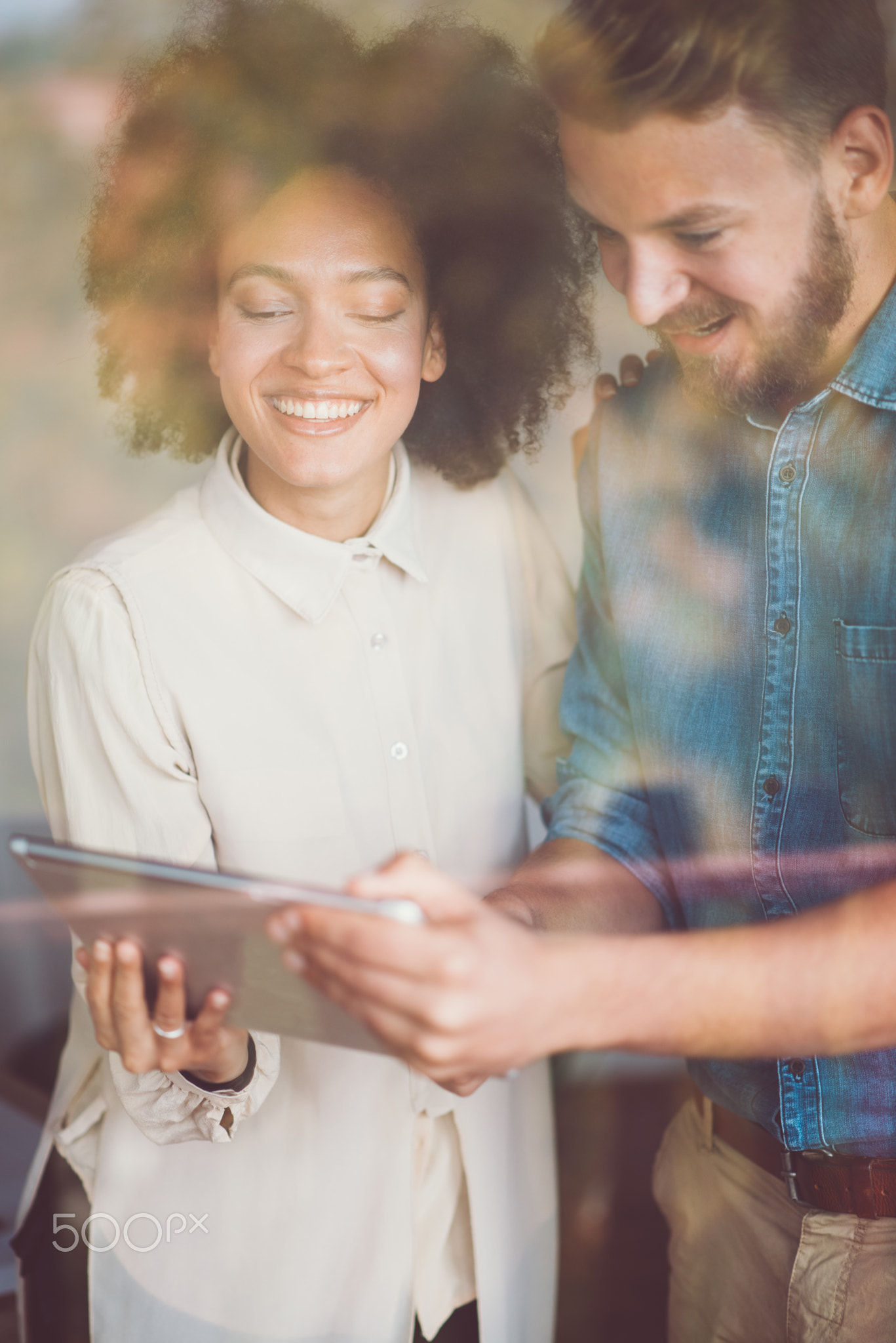 Man and woman using tablet.