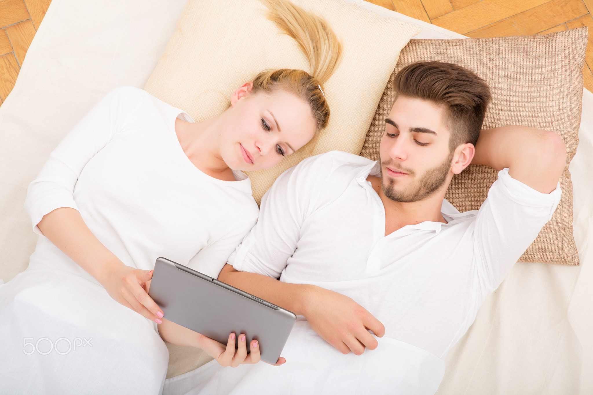 Young couple with a tablet PC in bed