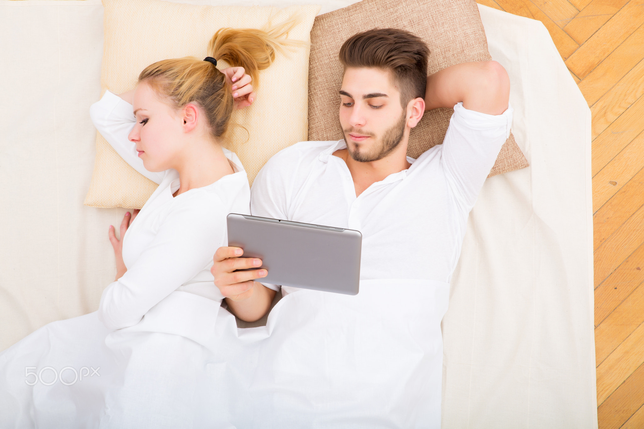 Young couple with a tablet PC in bed