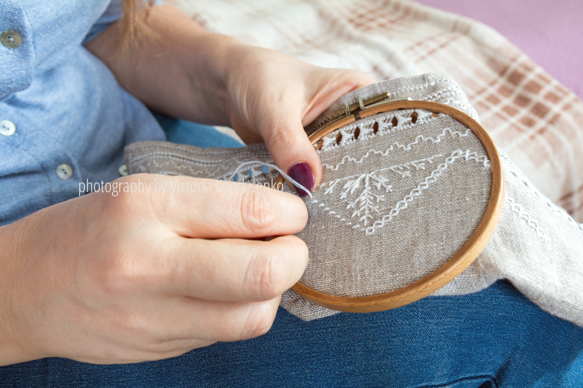 Woman hands doing openwork embroidery on homespun linen.