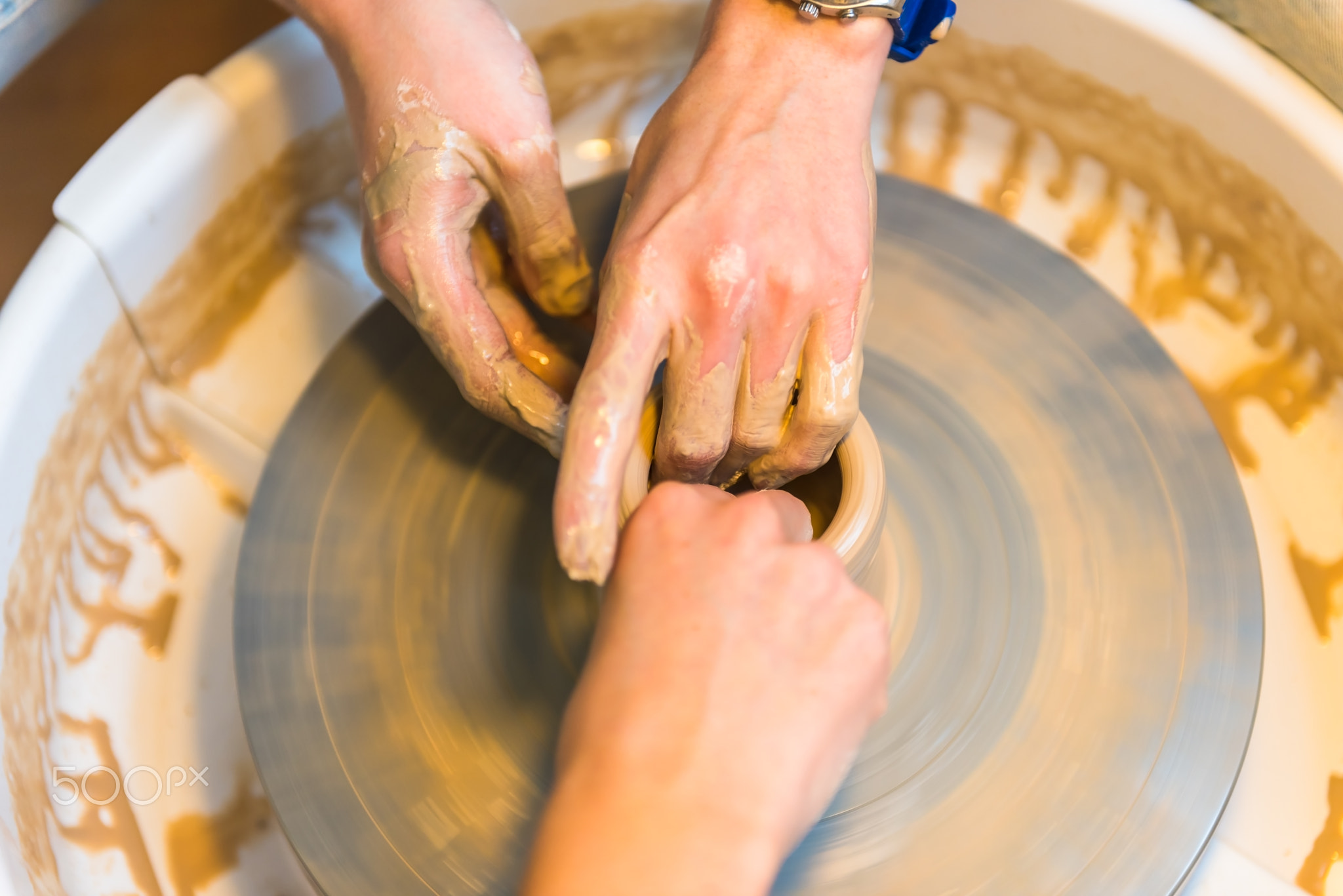 womens hands of a potter creating an earthen jar