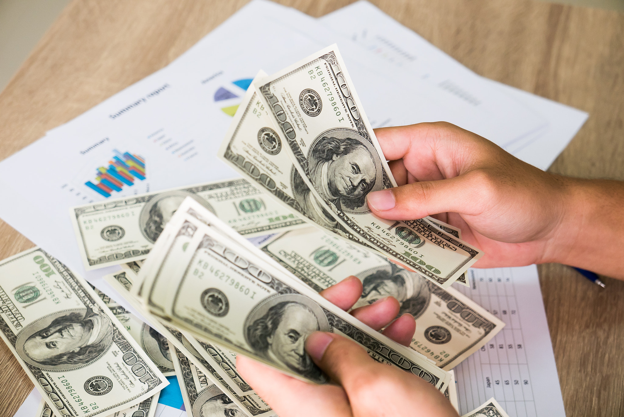 Closeup of Asian male hands counting bunch of dollars  banknotes