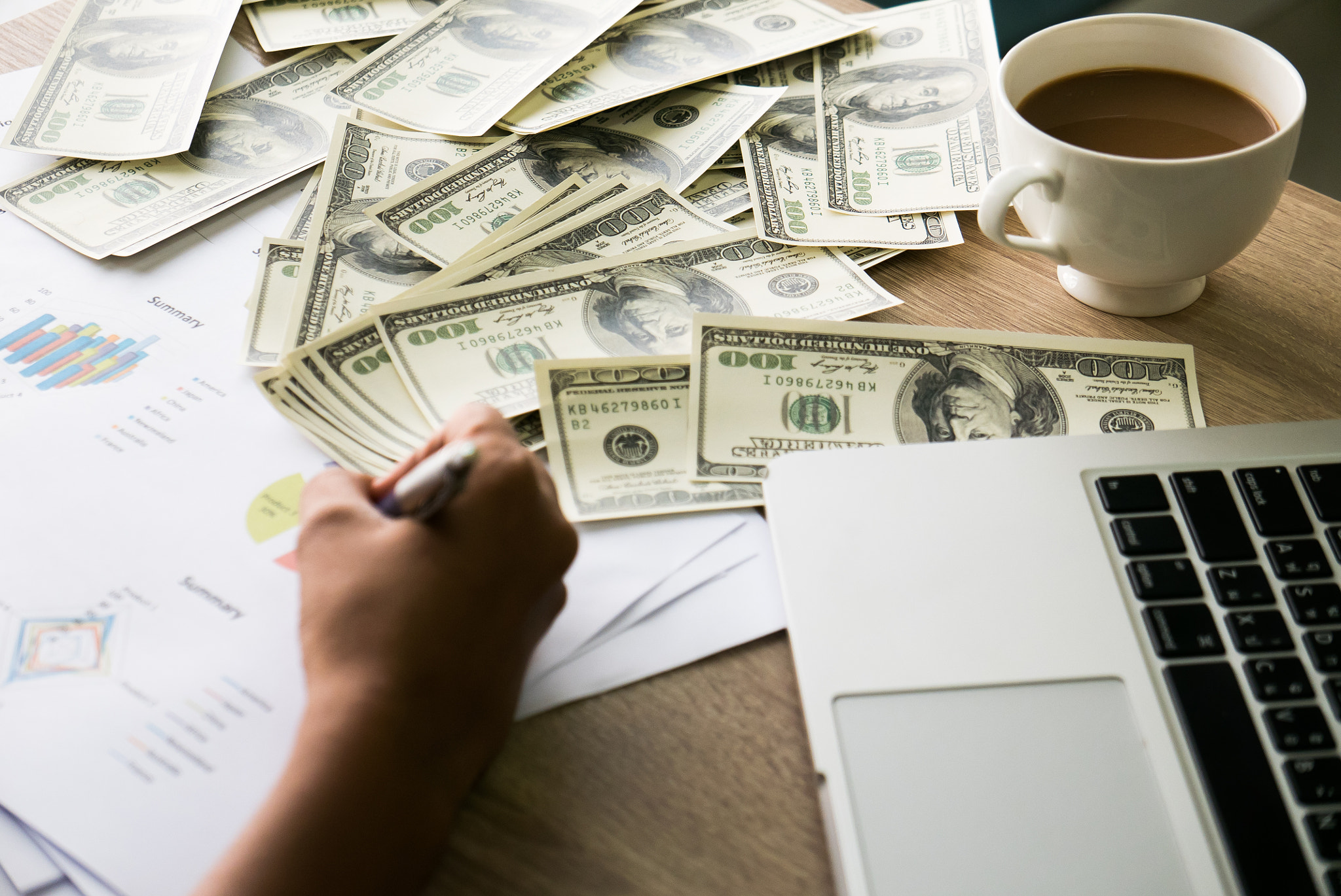 Closeup of Asian female hand writes something on business charts