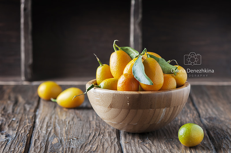 Nikon AF-S Micro-Nikkor 105mm F2.8G IF-ED VR sample photo. Fresh kumquat with green leaves on the wooden table photography