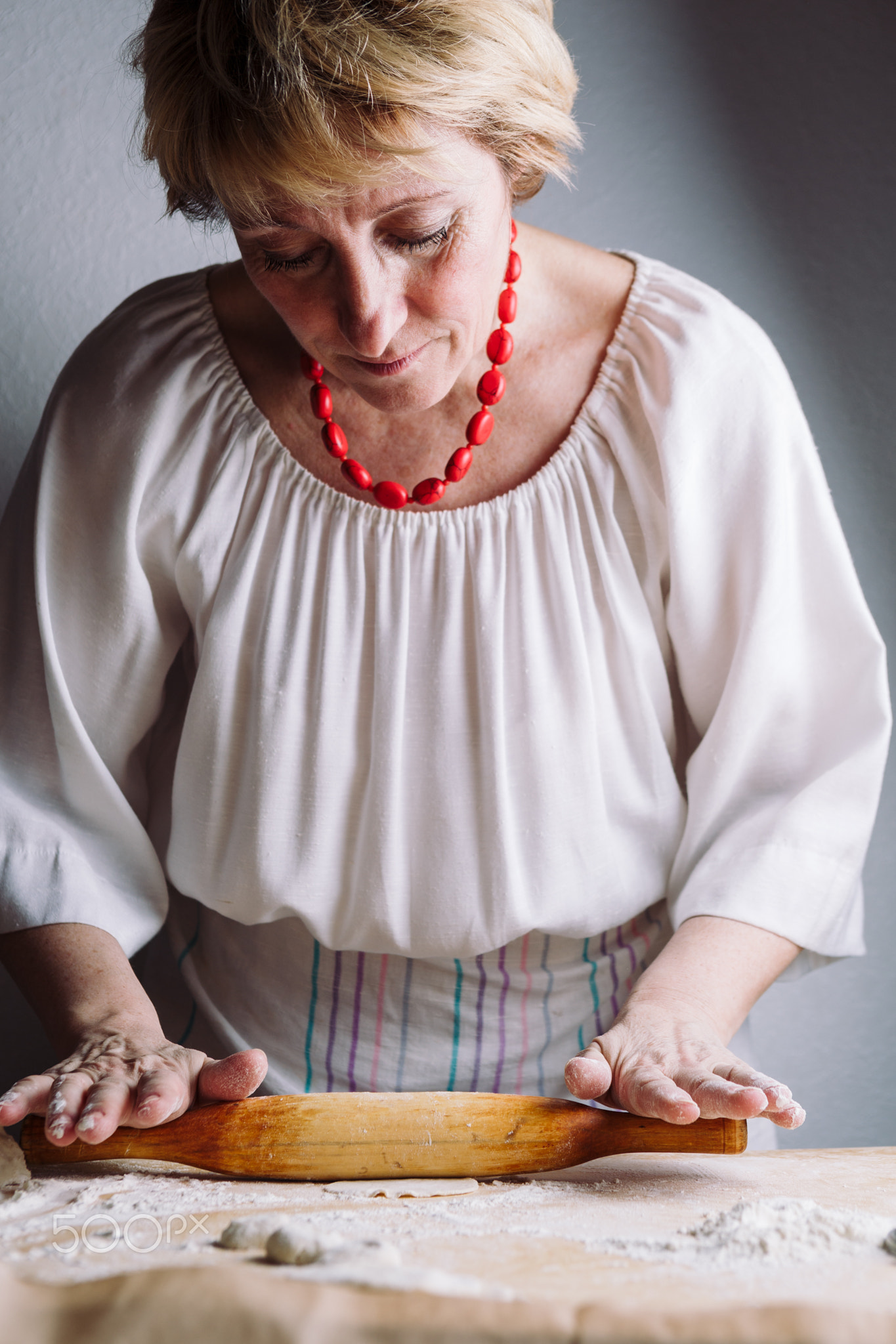 Making meat dumpling with wooden rolling pin.