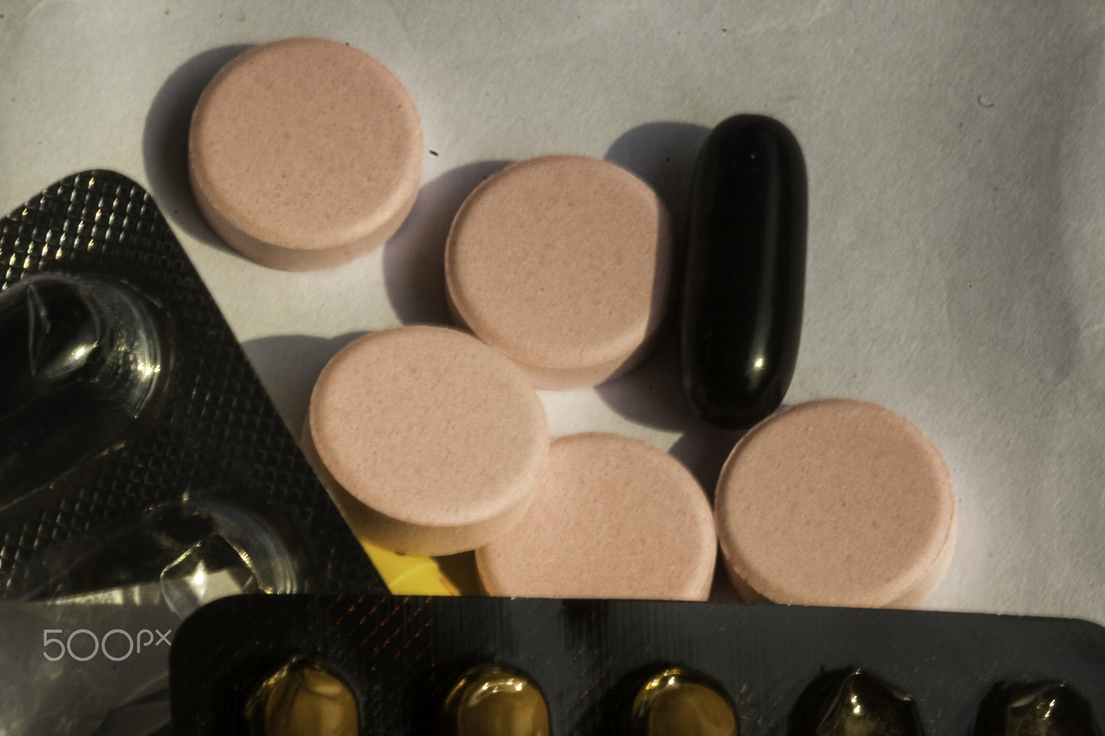 Canon EF 100mm F2.8 Macro USM sample photo. Pink and black medicine tablets along with a yellow capsule and photography