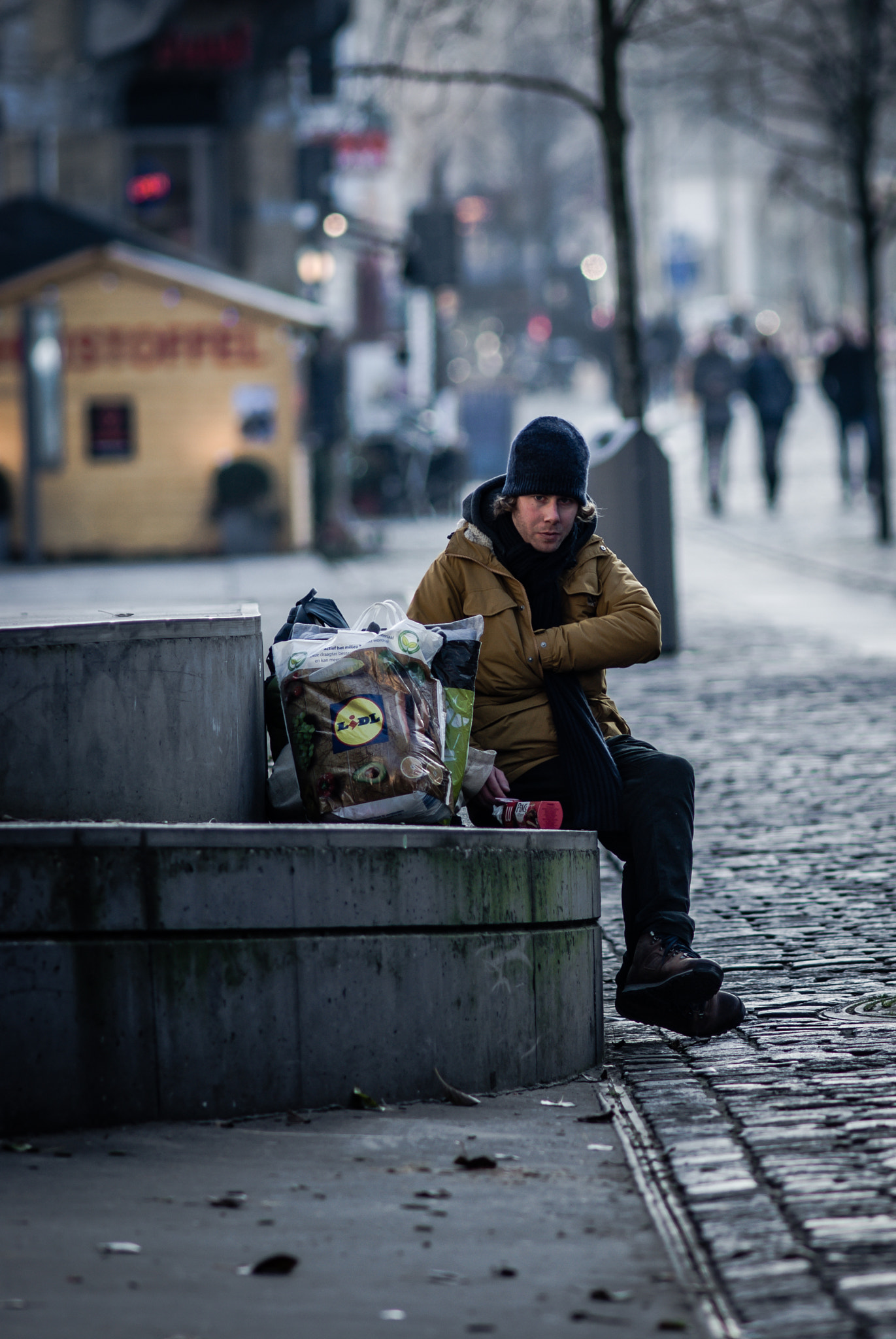 Sony Alpha DSLR-A200 + Minolta AF 200mm F2.8 HS-APO G sample photo. Man sitting with shoppingbags photography