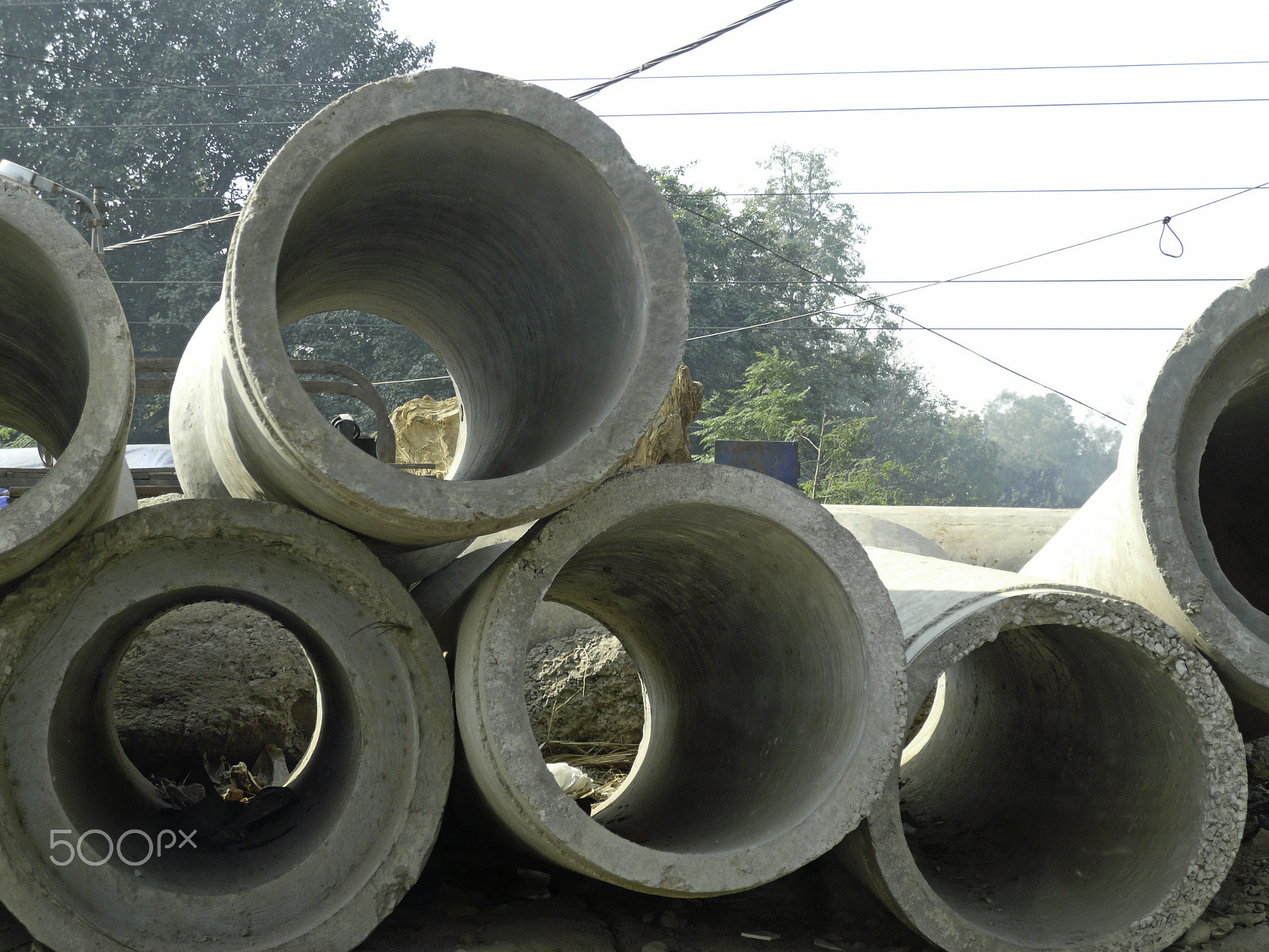 Panasonic DMC-FX100 sample photo. Large concrete sewage pipes piled, waiting for installation photography