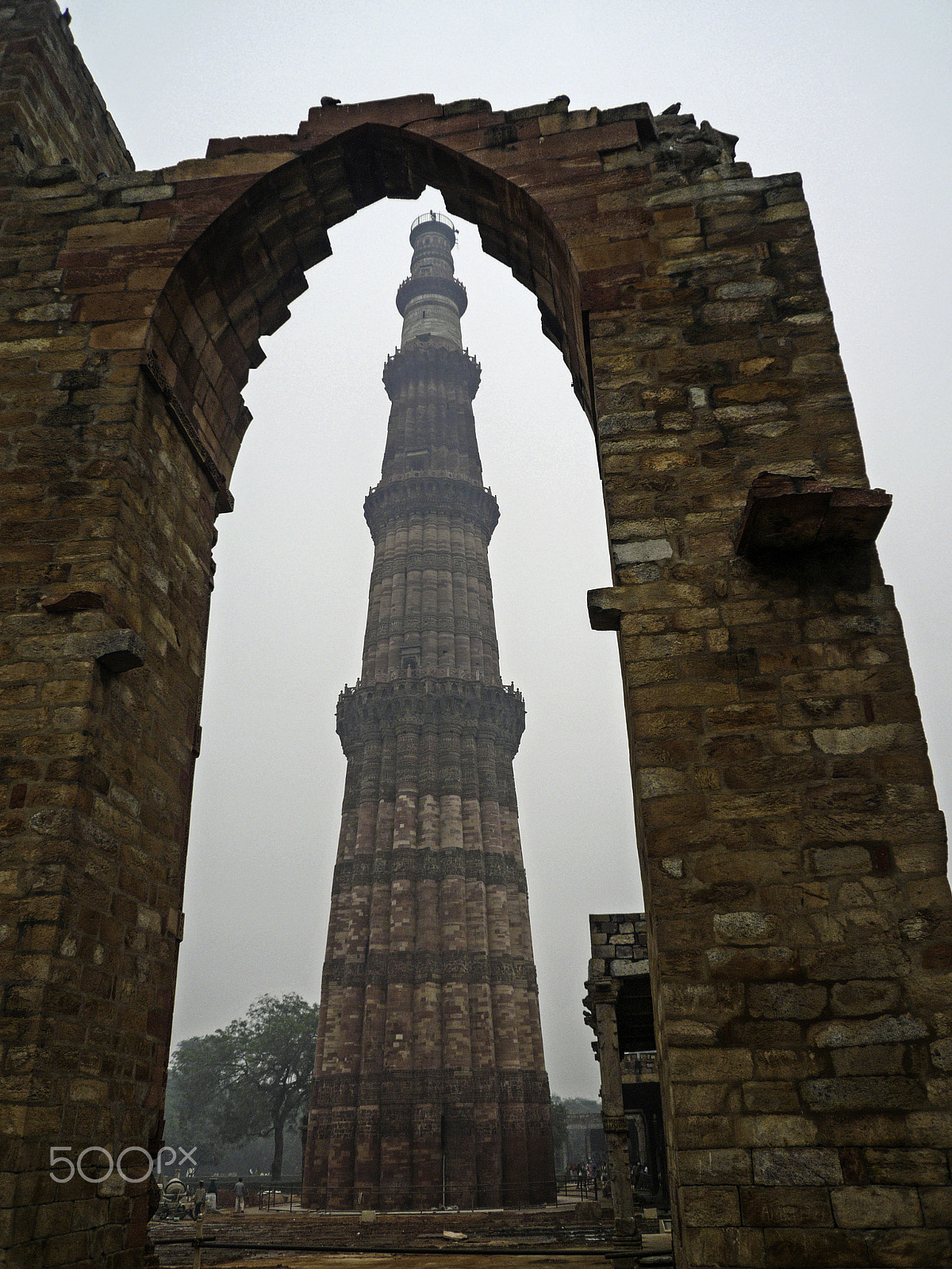 Panasonic DMC-FX100 sample photo. The qutub minar framed by remains of a stone wall photography