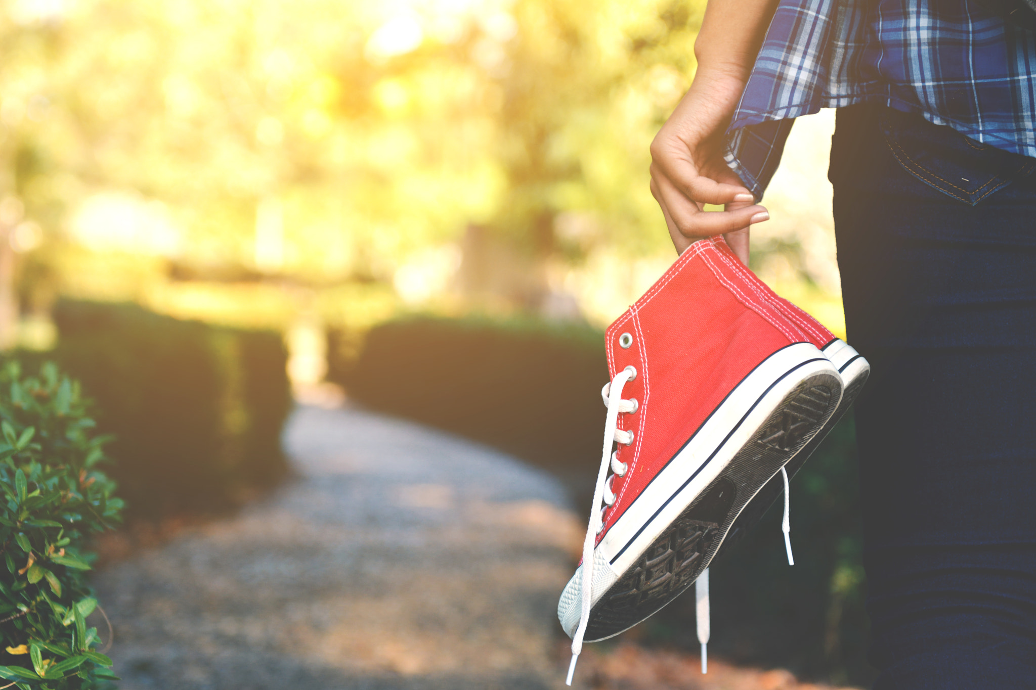 Nikon AF-S Nikkor 24-70mm F2.8G ED sample photo. Hipster women holding red sneaker in the park and relax time on holiday. vintage tone photography