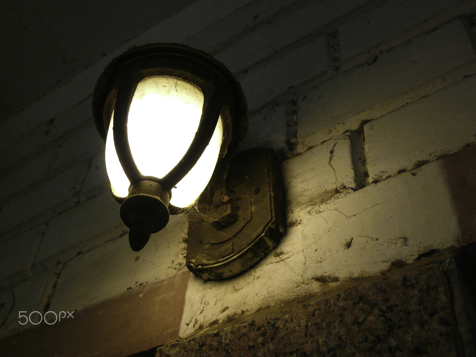 Panasonic DMC-FX100 sample photo. An old style electric lamp on a wall amidst dust and cobwebs photography