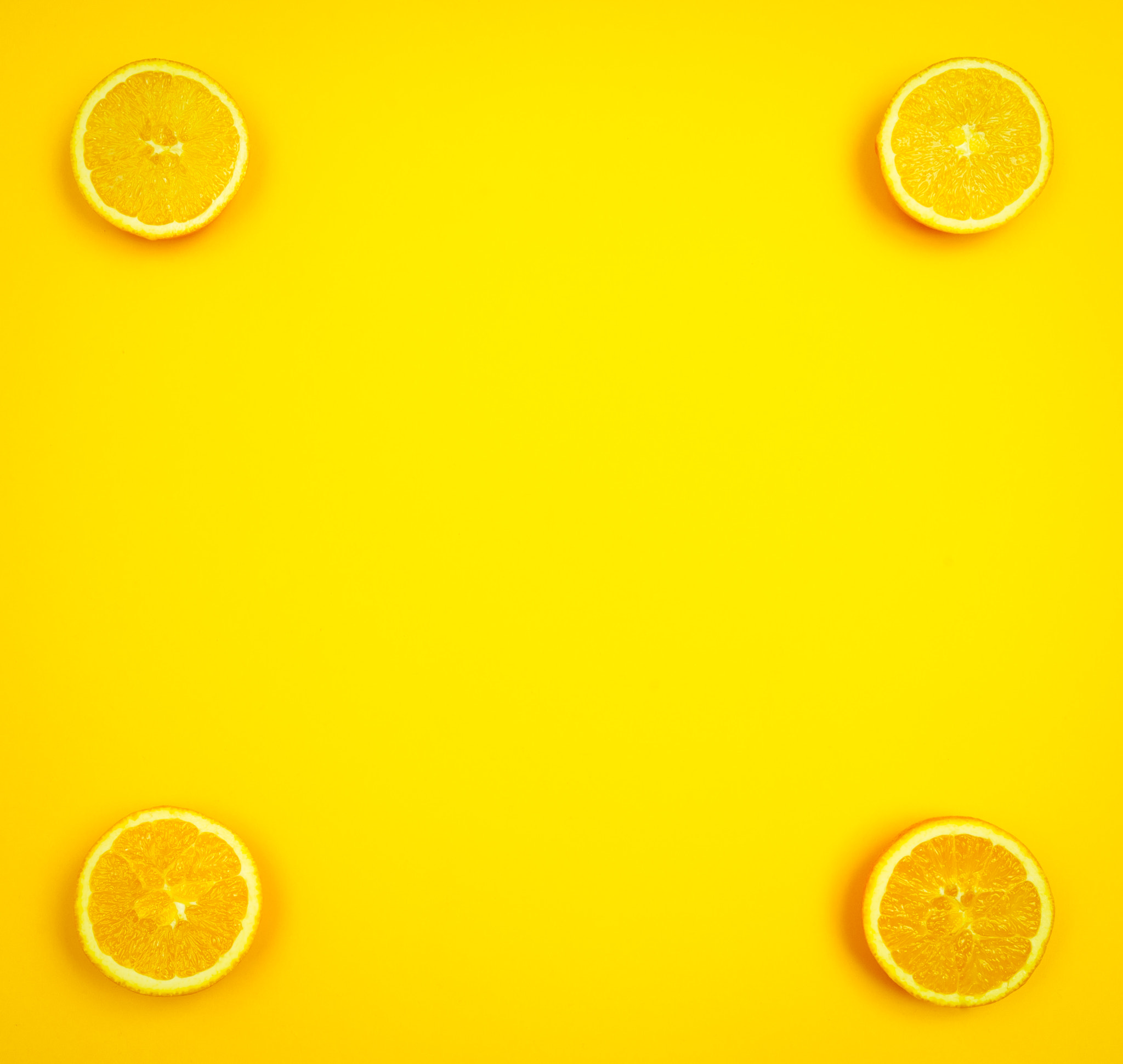 Nikon D2X sample photo. Orange slices on yellowish background with copy space photography