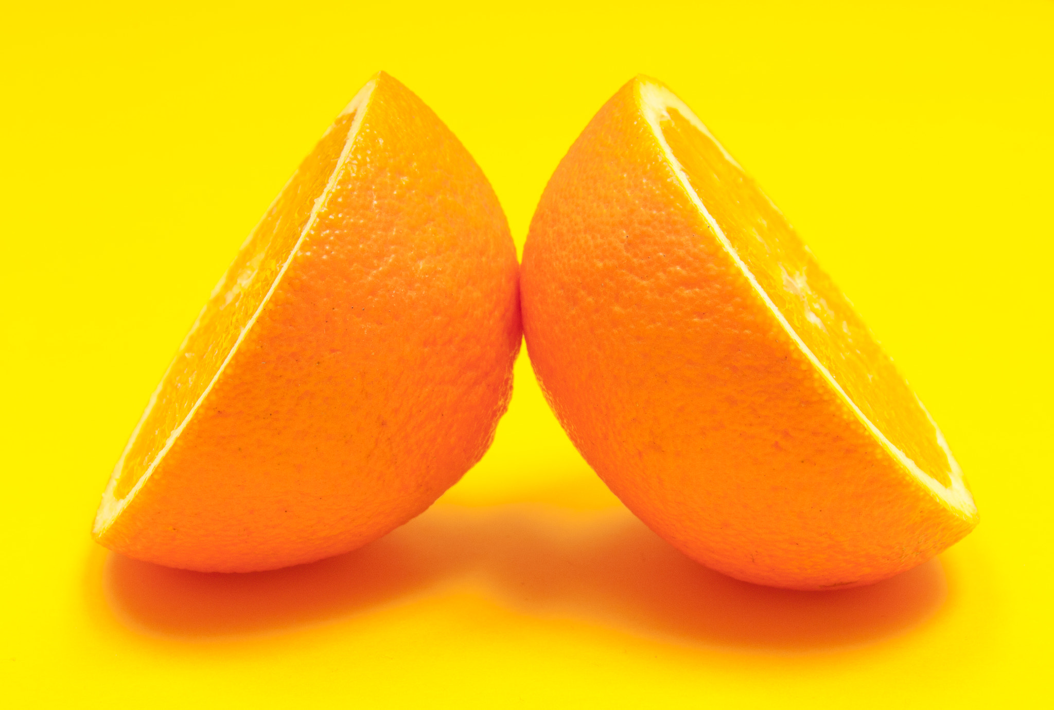 Nikon D2X sample photo. Half orange citrus fruit on yellow background photography