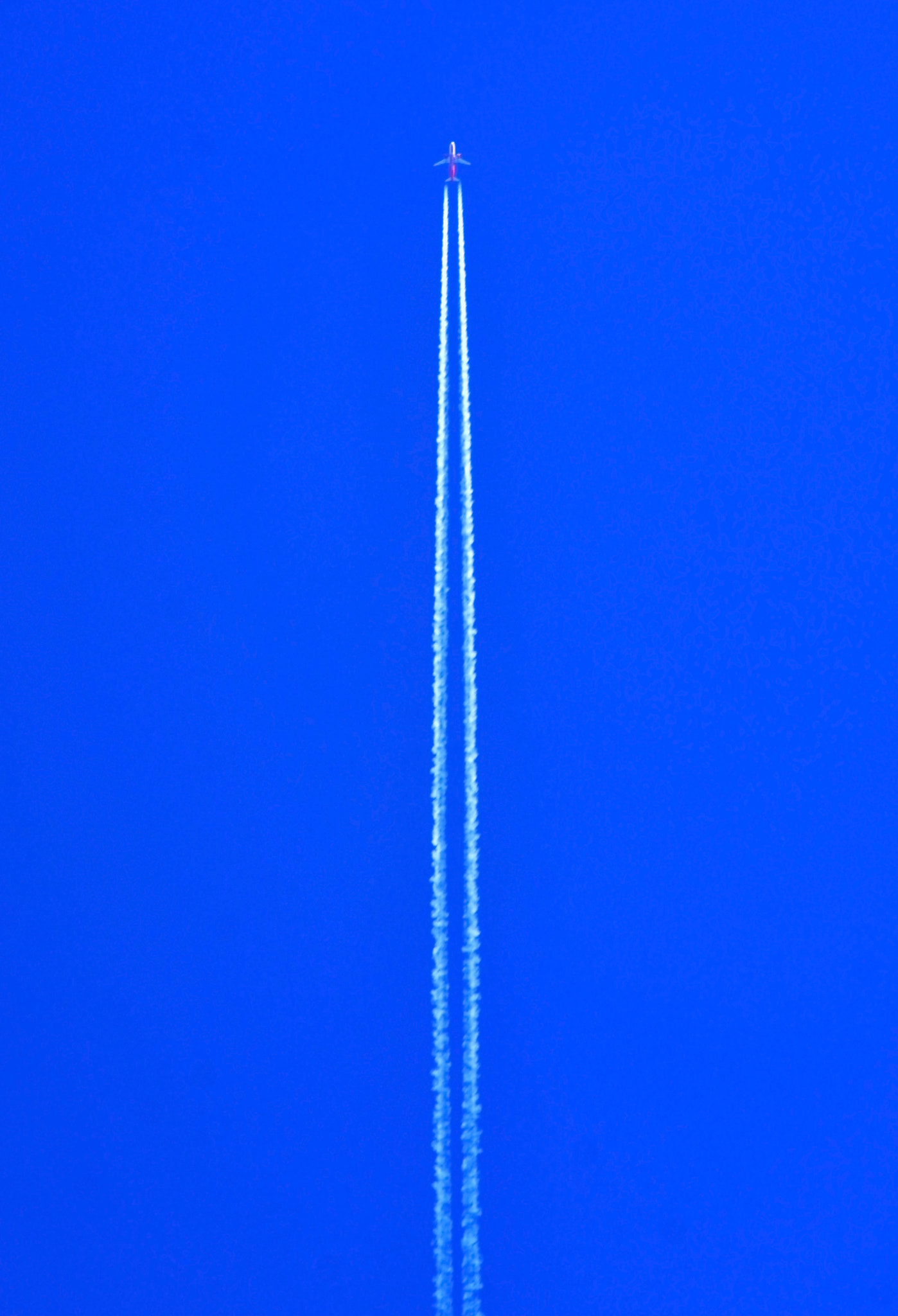 Nikon D7100 + Sigma 50-150mm F2.8 EX APO DC HSM II + 1.4x sample photo. Airplane flying at high altitude leaving its white wake over blu photography