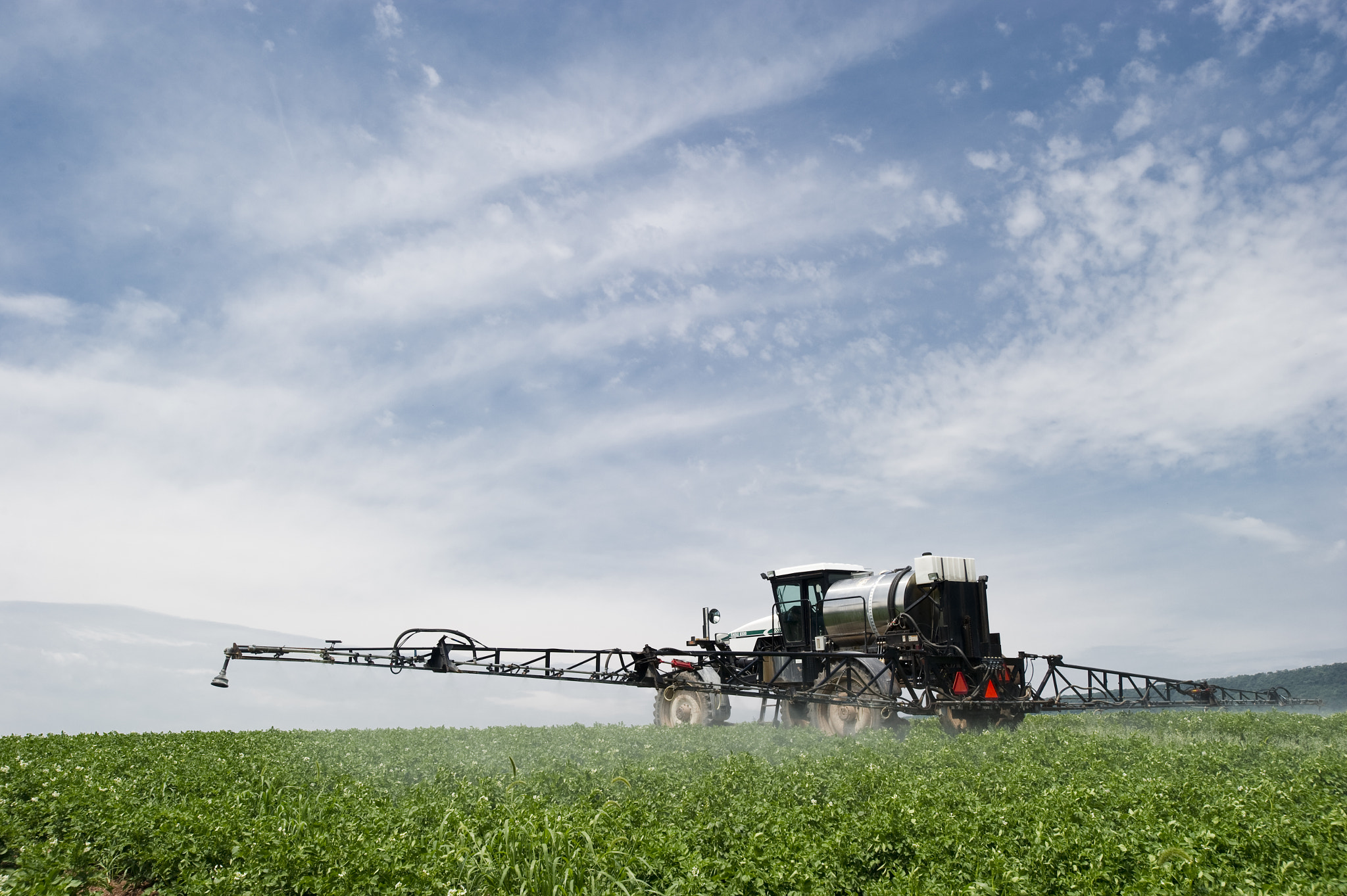 Nikon AF-S Nikkor 17-35mm F2.8D ED-IF sample photo. Field of potatoes being sprayed photography