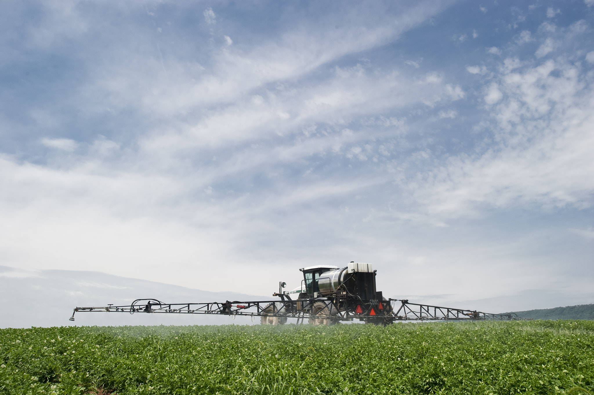 Nikon AF-S Nikkor 17-35mm F2.8D ED-IF sample photo. Field of potatoes being sprayed photography