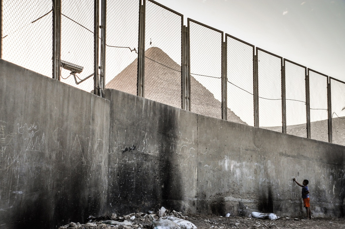 Nikon D700 sample photo. A boy writes on the wall in front of cairo pyramids photography