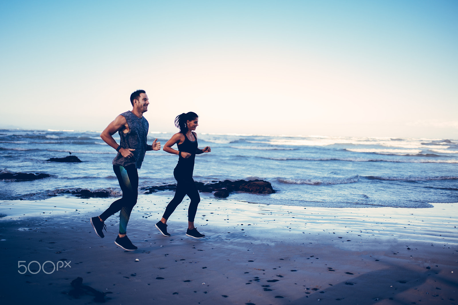Canon EOS 5DS sample photo. Fit young adult couple running on beach photography