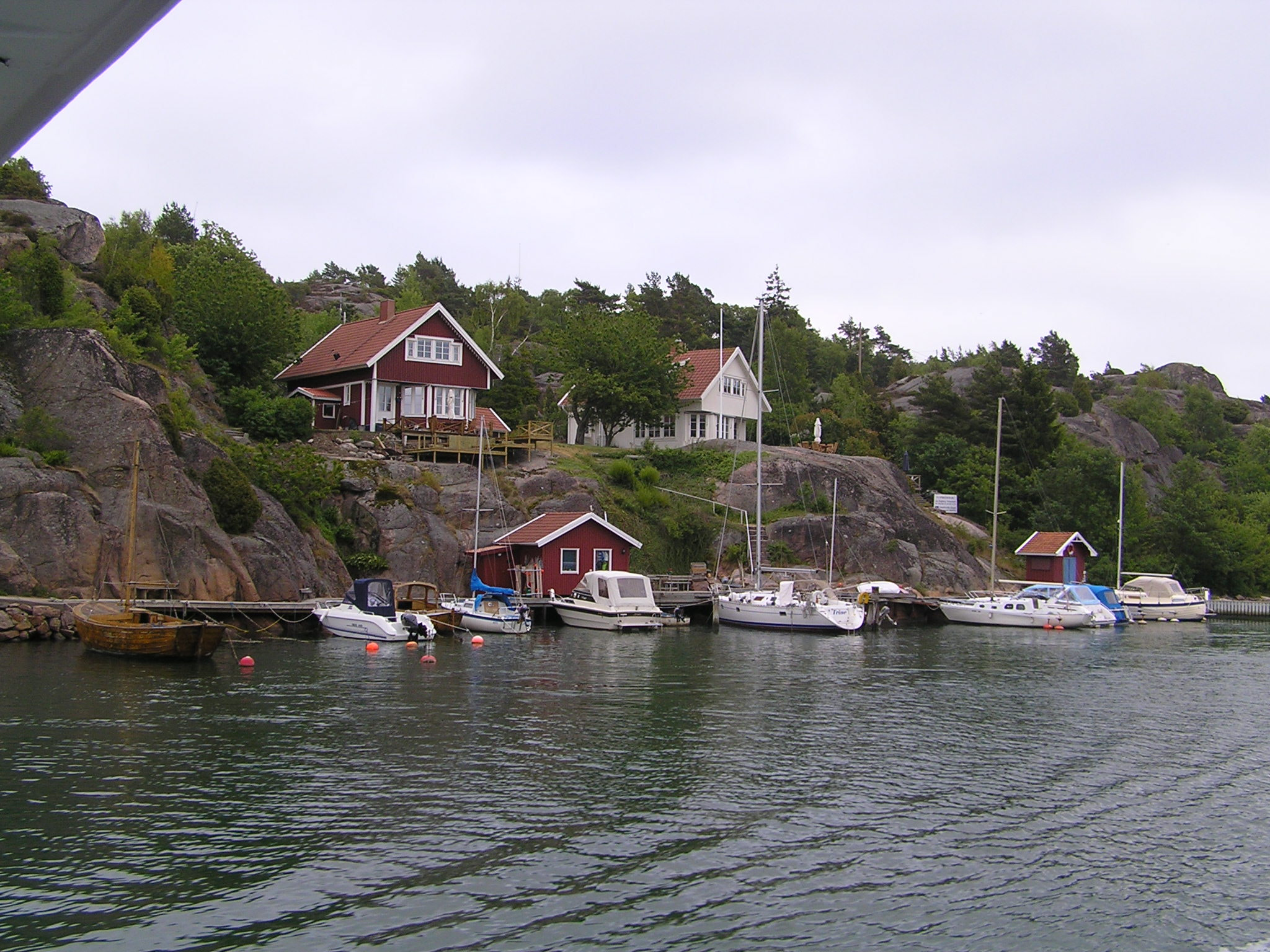 Olympus C760UZ sample photo. Rocky bank of the river with boats and homes photography