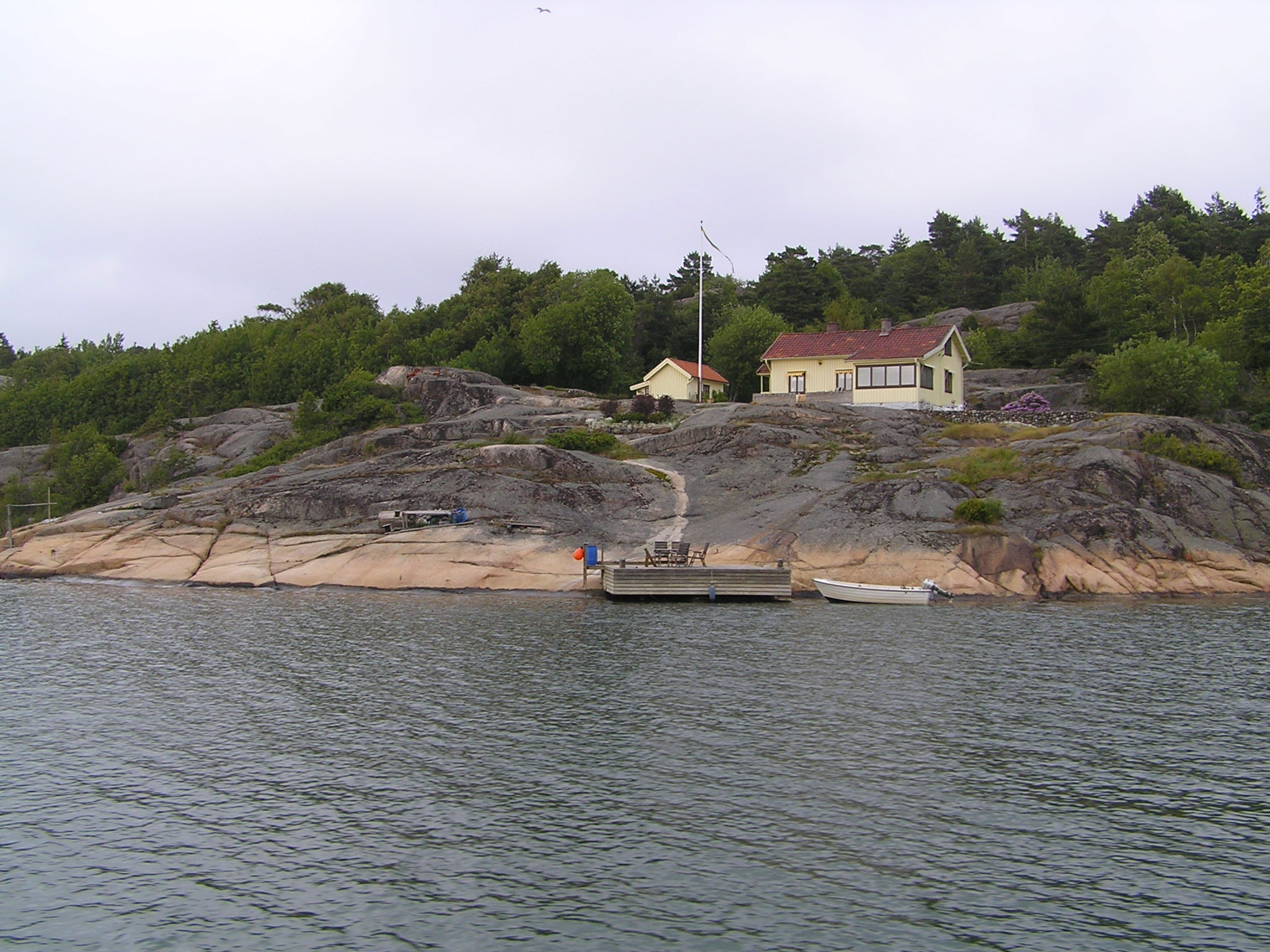 Olympus C760UZ sample photo. Rocky bank of the river with homes and green trees photography